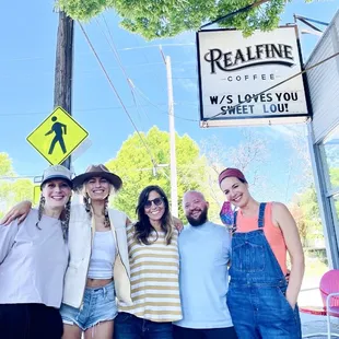 a group of people standing in front of a coffee shop