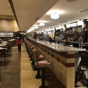 a restaurant with rows of bar stools