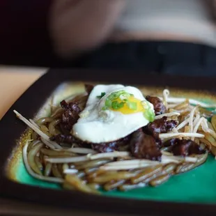 a plate of noodles with a fried egg on top