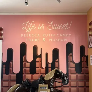 a statue of a horse in front of a sign that says life is sweet