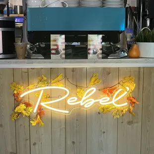a neon sign that reads rebel