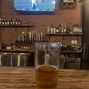 a glass of beer on a bar