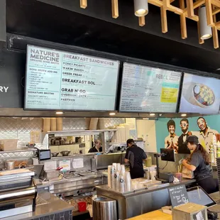 a restaurant counter with a menu on the wall