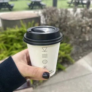 a hand holding a coffee cup