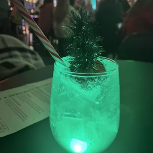 a glass of water with a christmas tree in it