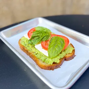 a sandwich with avocado and tomatoes