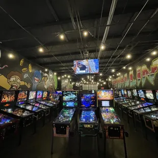 a row of pinball machines in a game room