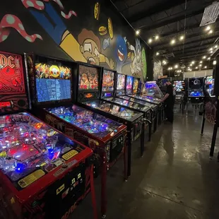 a row of pinball machines in a game room