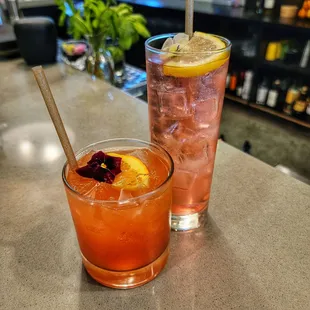 two glasses of drinks on a counter