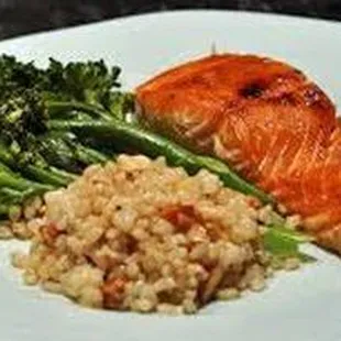 a plate of salmon, broccoli and rice