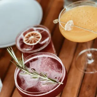 a variety of cocktails on a wooden table
