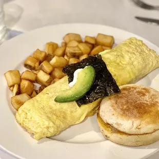an omelet with a side of potatoes and avocado