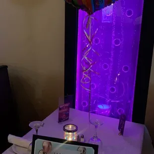 a table with a birthday card and a balloon