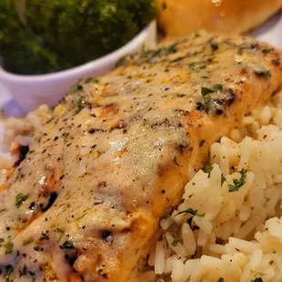 Salmon with white wine garlic butter sauce over rice and garlic butter streamed Broccoli.