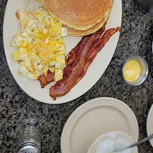 2 hotcakes , 2 eggs ,  2 bacon ,  added side of grits