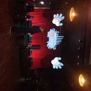 a stage with a red curtain and a red chair