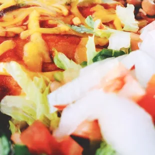 a salad with beans, lettuce, tomatoes, and cheese