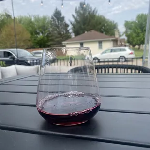 a glass of red wine on a table