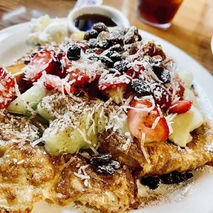 a plate of french toast topped with fruit and cheese