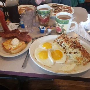 a woman sitting at a table with breakfast items