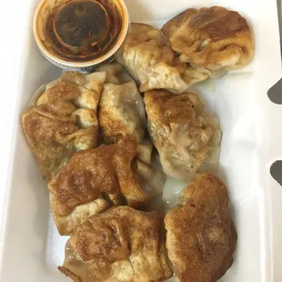a plate of dumplings and dipping sauce