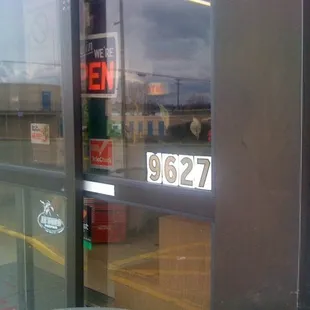 a gas station with a clock on the door