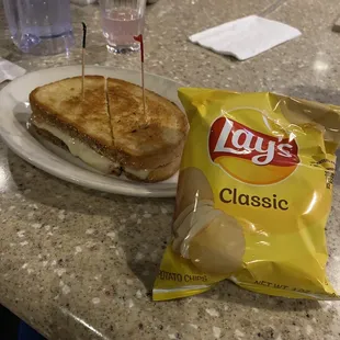 Grilled cheese with Swiss and ham on rye and chips