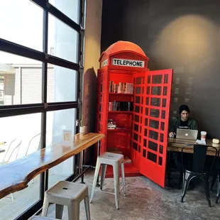 a red phone booth in a coffee shop