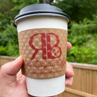 a hand holding a coffee cup