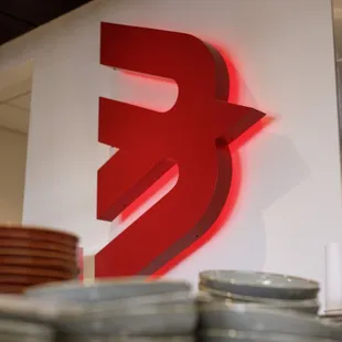 a stack of plates in front of a red bird logo