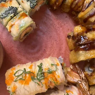 Hungry Hunter roll (topped with the dark roe), Dynamite roll (topped with eel sauce), and Snow White roll (topped with orange roe)
