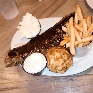 a plate of ribs, fries and coleslaw