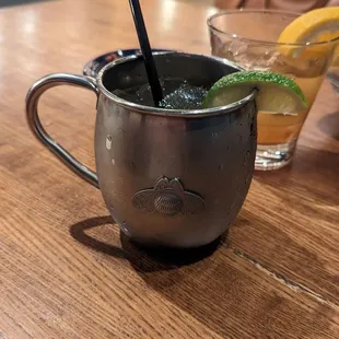 a drink in a mug with a straw and a lime