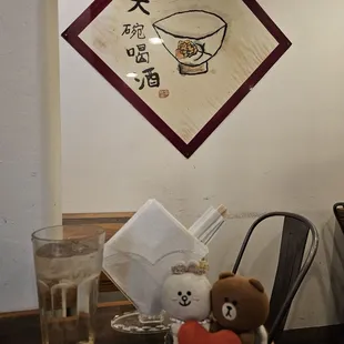 Glass of water, napkin holder, and wall decoration