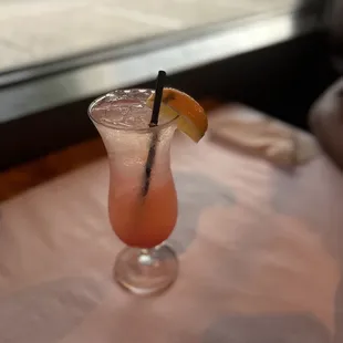 a glass with a drink on a table