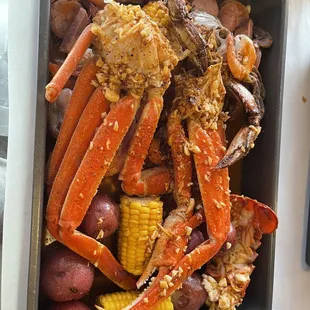 crab legs, corn, potatoes, and corn on the cob