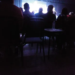 a group of people sitting in a dark room