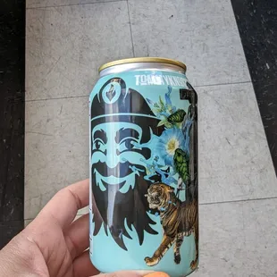 a hand holding a can of beer
