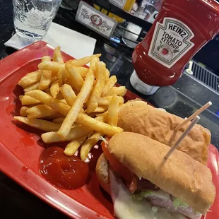 a sandwich and fries on a red plate