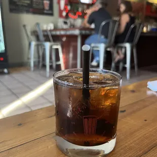a glass of iced tea on a wooden table