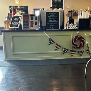 a cafe counter with a sign and a chair