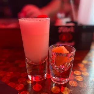 a shot of a drink and a shot of orange juice