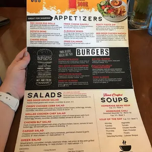 a person holding up a menu