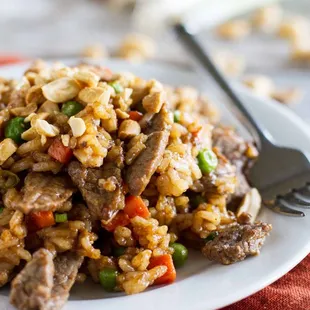 a plate of rice with meat and vegetables