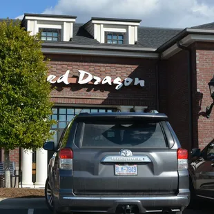 a silver van parked in front of a restaurant