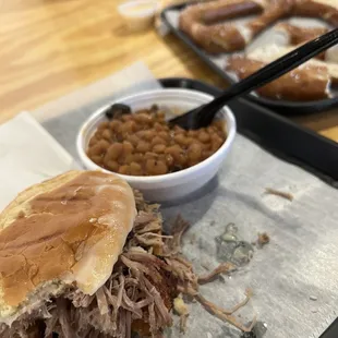 shows a pulled pork sandwich and baked beans