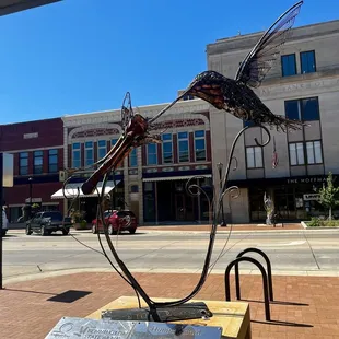 Looking through the statue across the street at the storefront