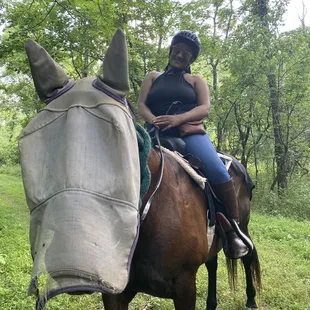Me and Anie (the horse). The face covering is to keep the flies out of her eyes and nose. She can still see through it, it&apos;s just a net.