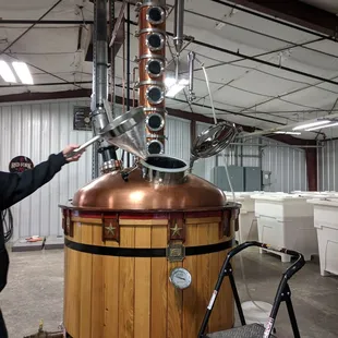 a man pointing at a copper pot