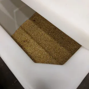 a white toilet with sand in it